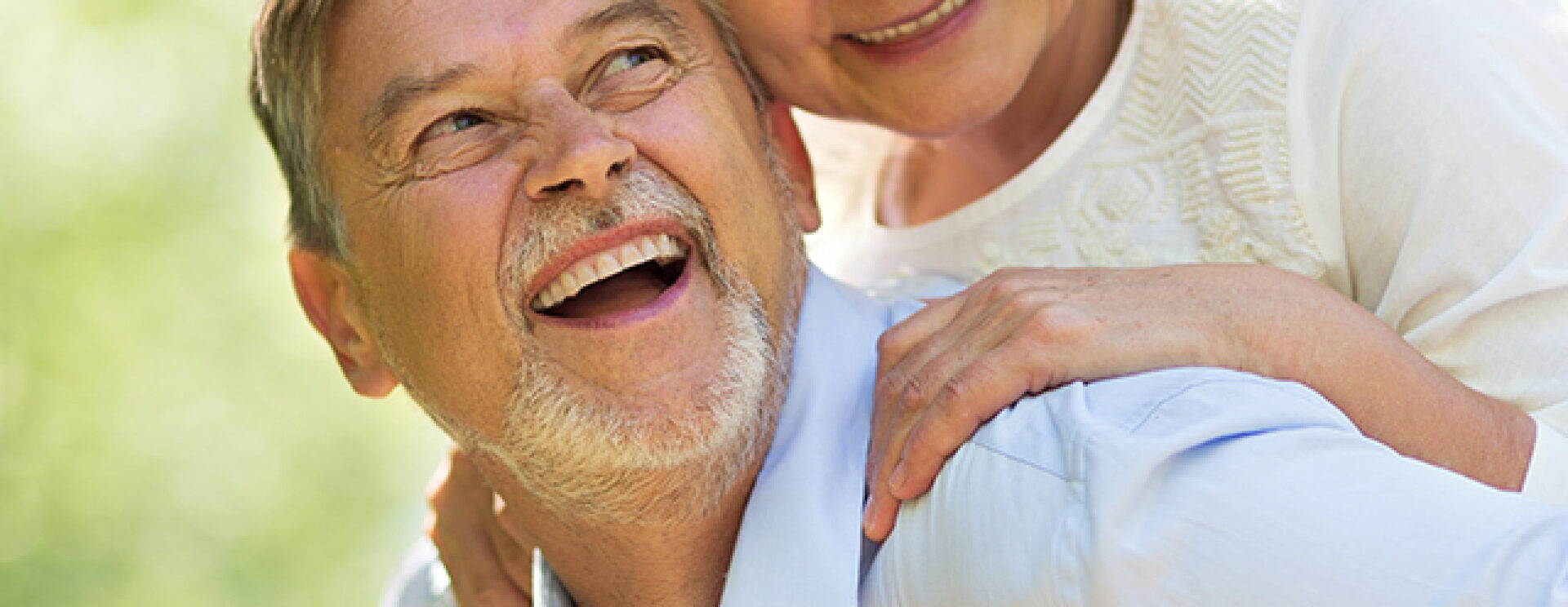un homme porte une femme sur son dos en souriant