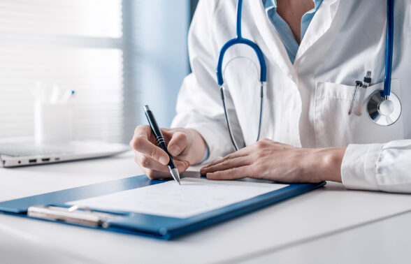 médecin assis à son bureau rédige une prescription sur ordonnance. - Agrandir l'image, fenêtre modale